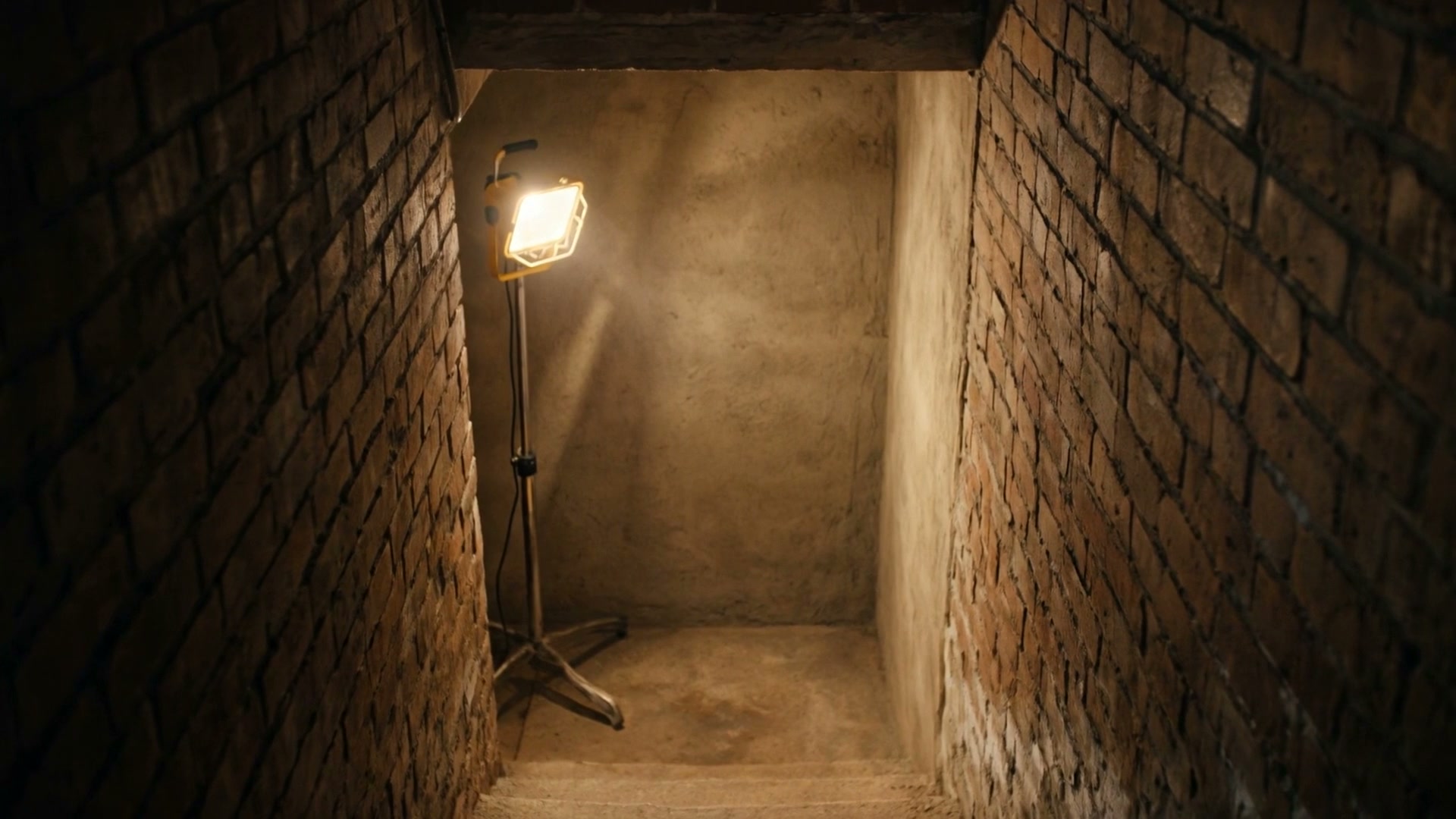 Mur de cave assaini, éclairé par une lampe de chantier, illustration