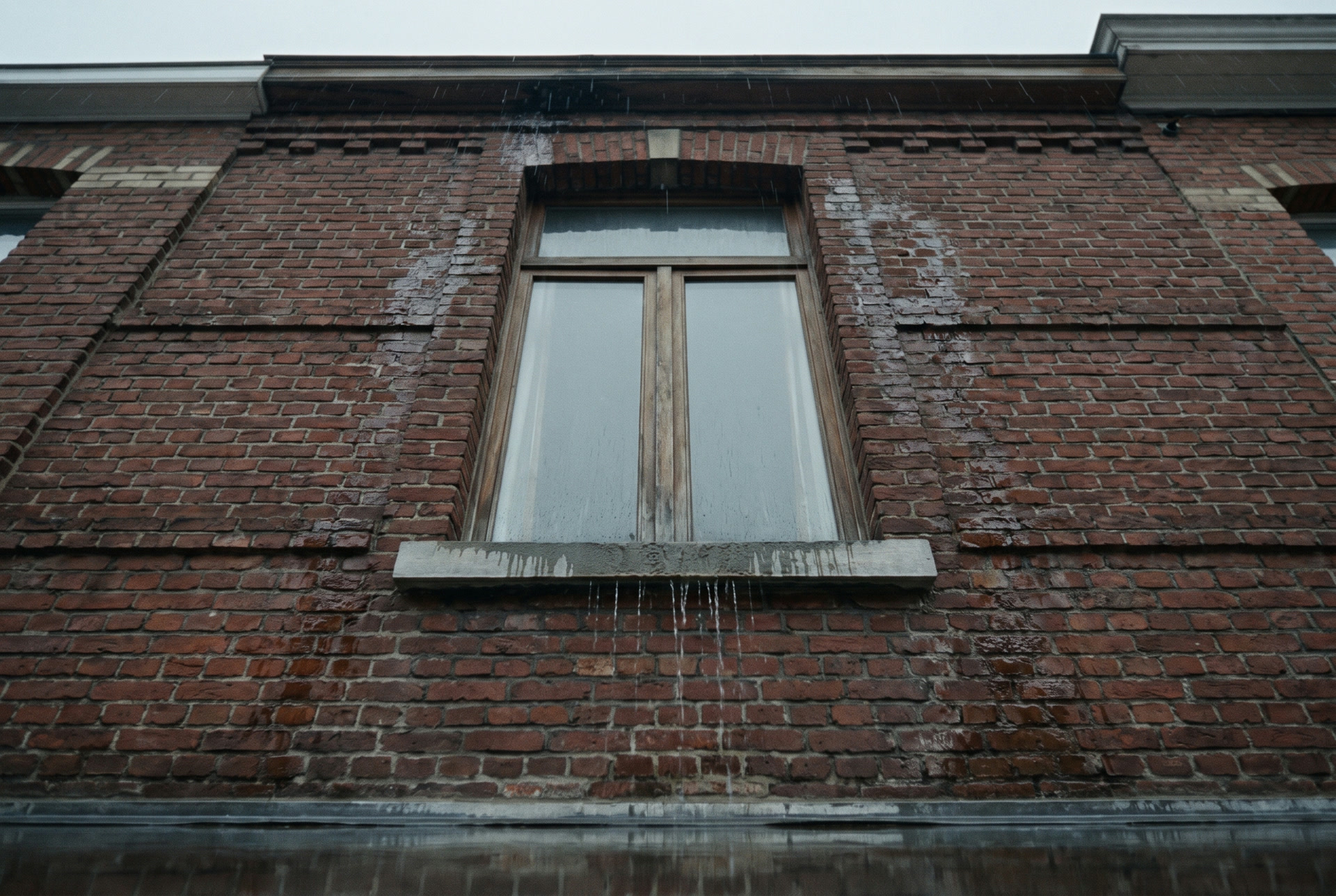 Façade en brique bruxelloise sous la pluie